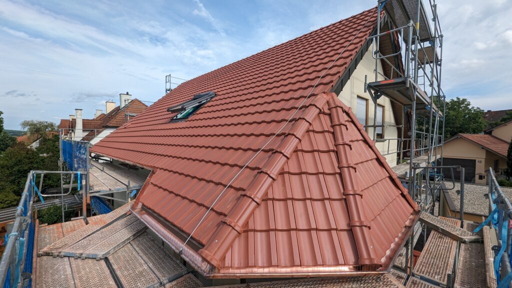 Aufnahme eines neuen roten Daches mit Baugerüst