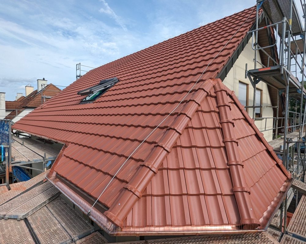 Aufnahme eines neuen roten Daches mit Baugerüst