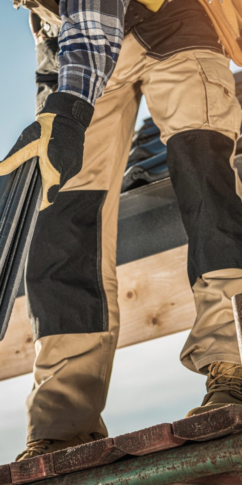 Bauindustrie. Dachdecker mit Keramikziegeln in den Händen. Nahaufnahme eines Dacharbeiters. Hausdachdeckung.